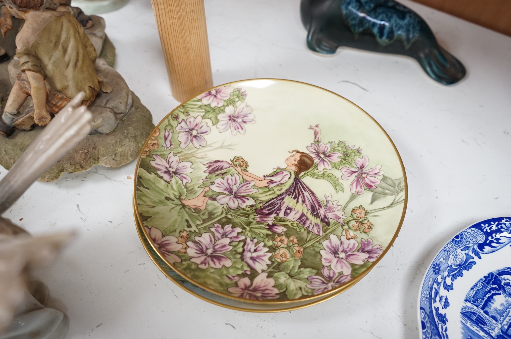 A collection of pottery and porcelain to include a Hayle model of a seal, Lladro figures and a pair of Fairy cabinet plates, largest 27cm wide